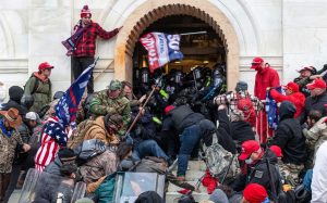 Protesters storming a building, clashing with police inside.